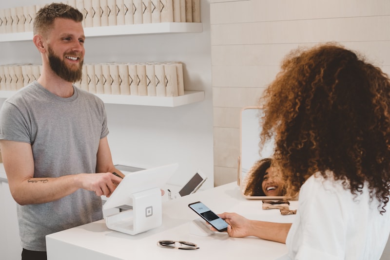Shop owner taking a contactless payment at a retail counter